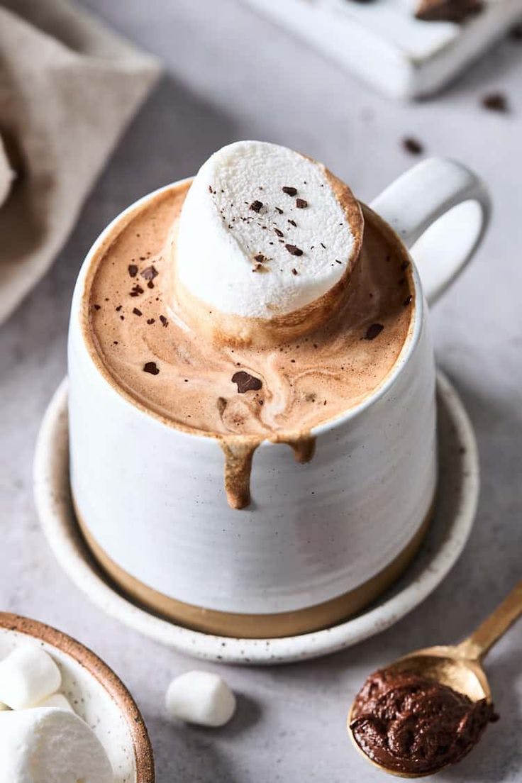 a piece of cake on a plate next to a cup of coffee