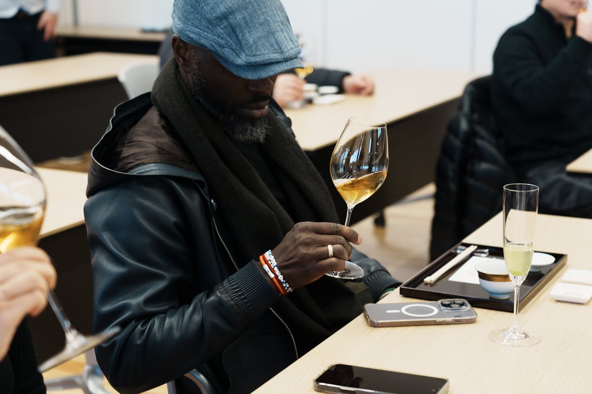 a group of people sitting at a table with a glass of wine