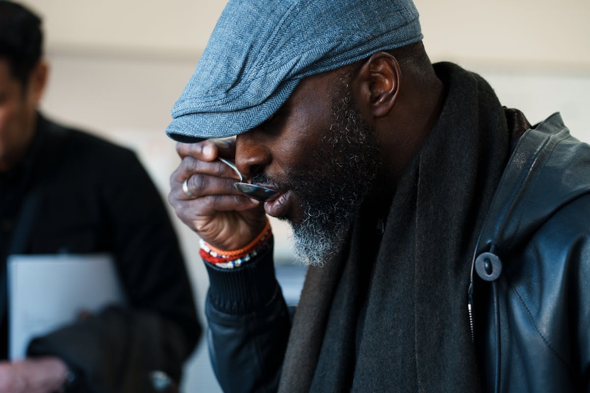 a man wearing a hat talking on a cell phone
