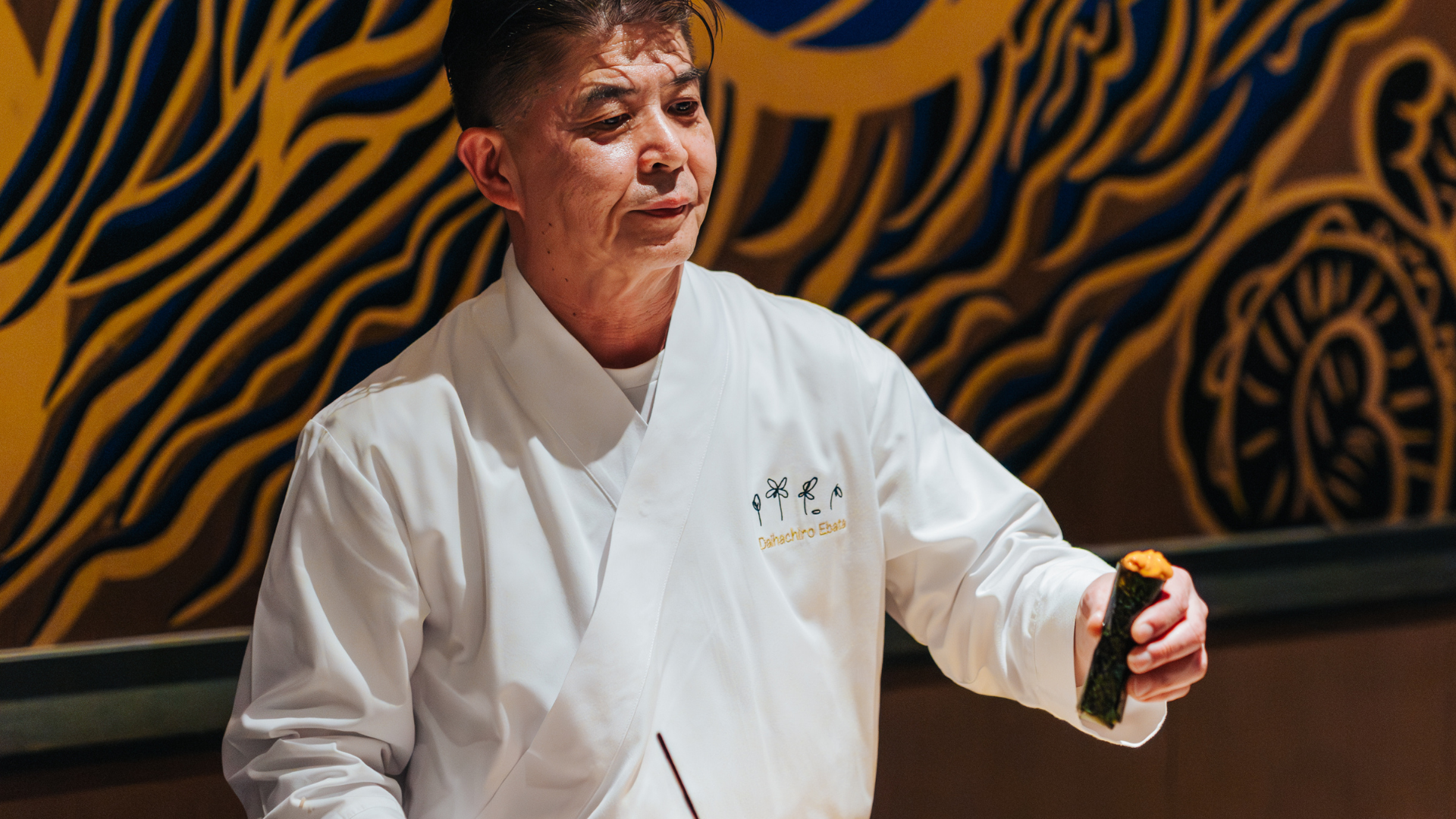 a man in a white robe holding a green object