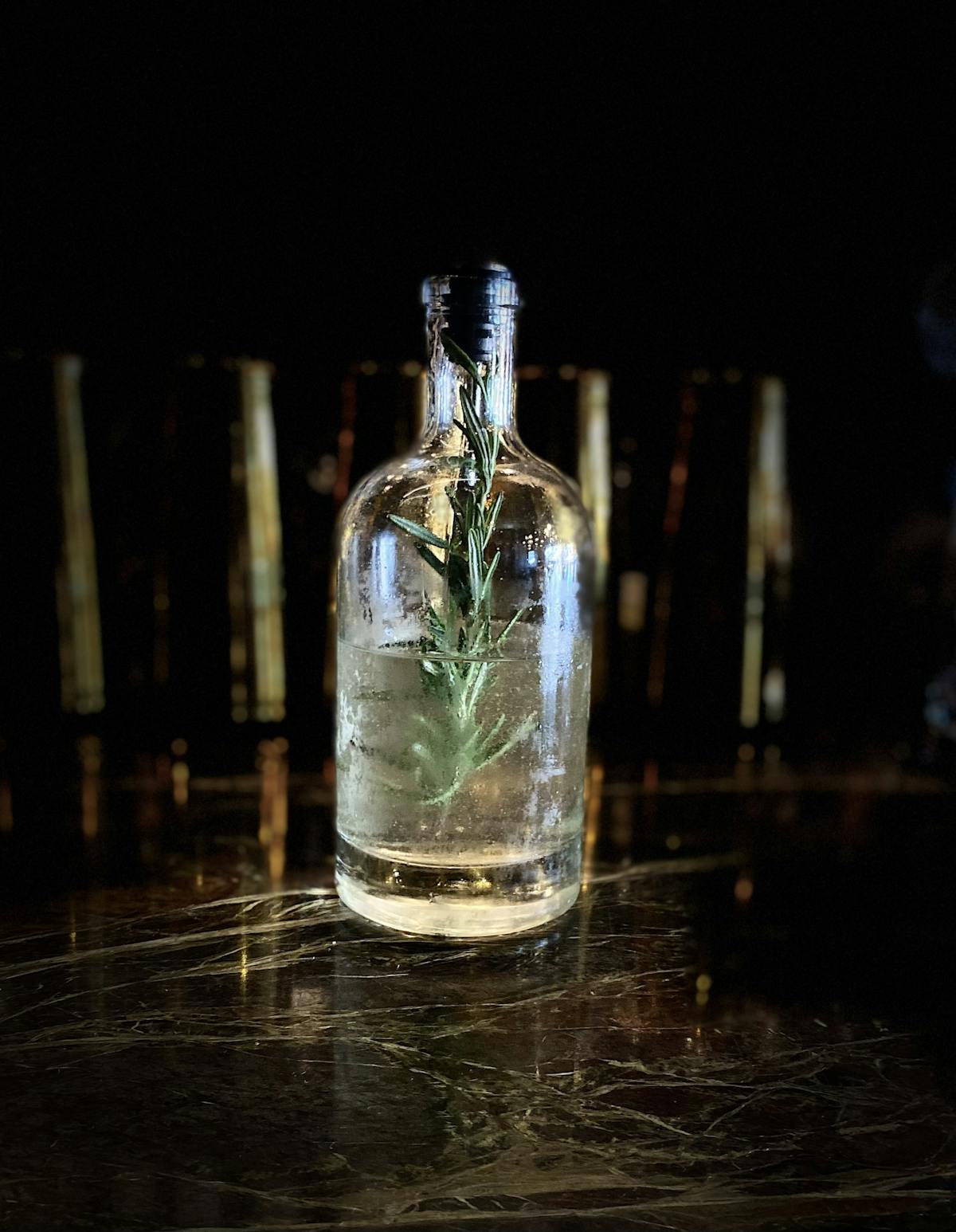 a close up of a bottle and a glass of water