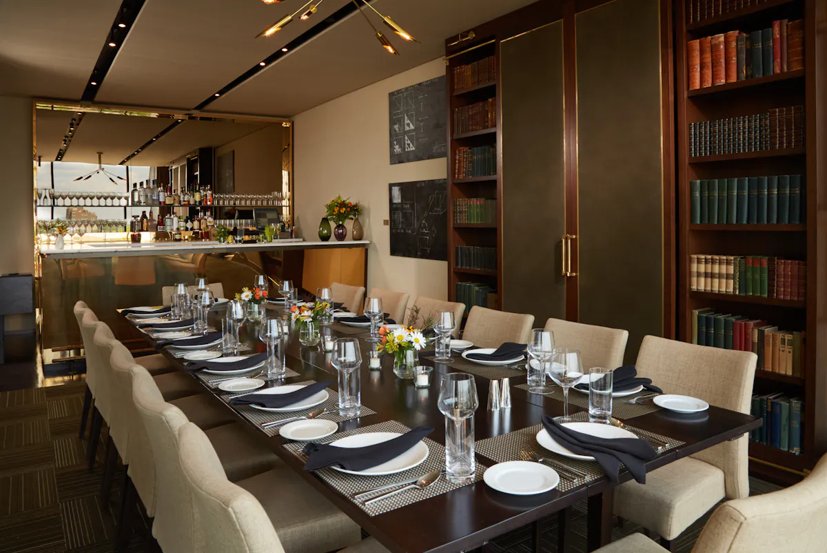 a dining room table in front of a book shelf