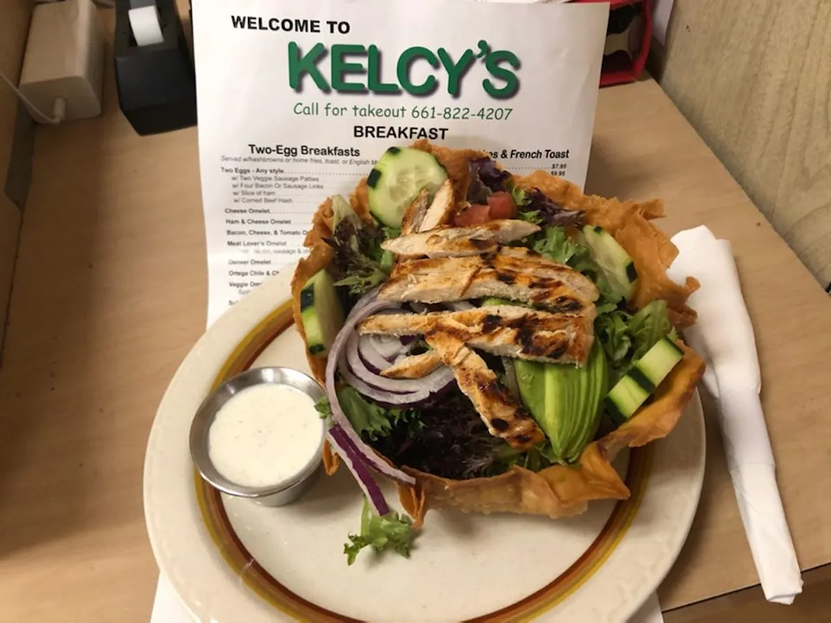 a sandwich sitting on top of a plate of food on a table