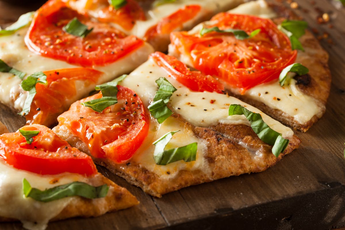 a slice of pizza sitting on top of a wooden cutting board