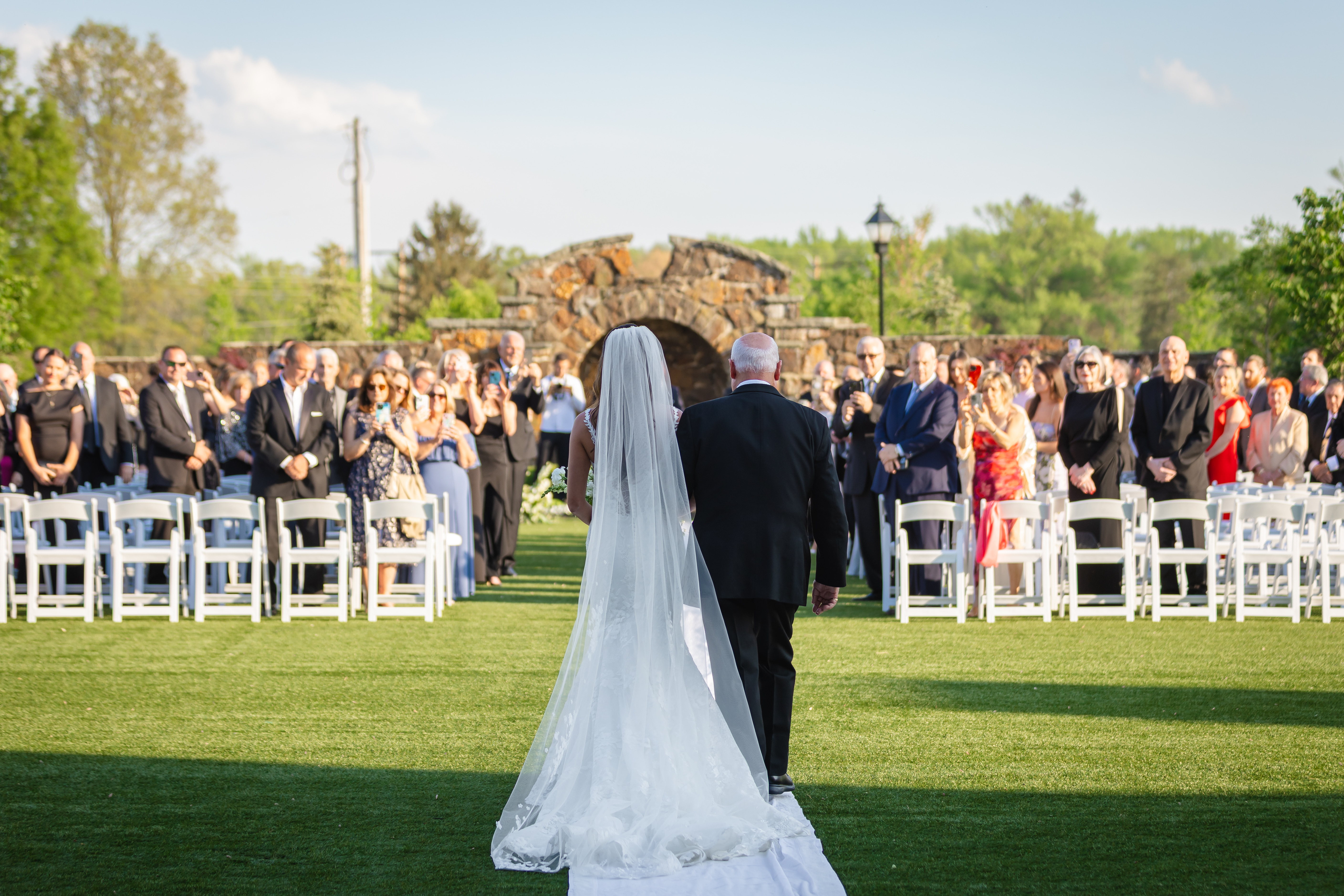 a group of people standing on top of a grass covered field