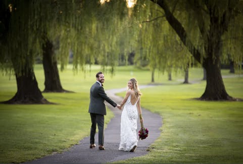 a person walking down a street next to a tree