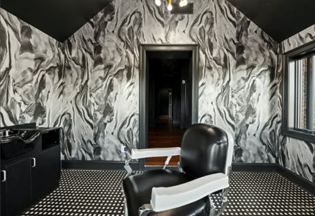 a bedroom with a bed and a chair in a room