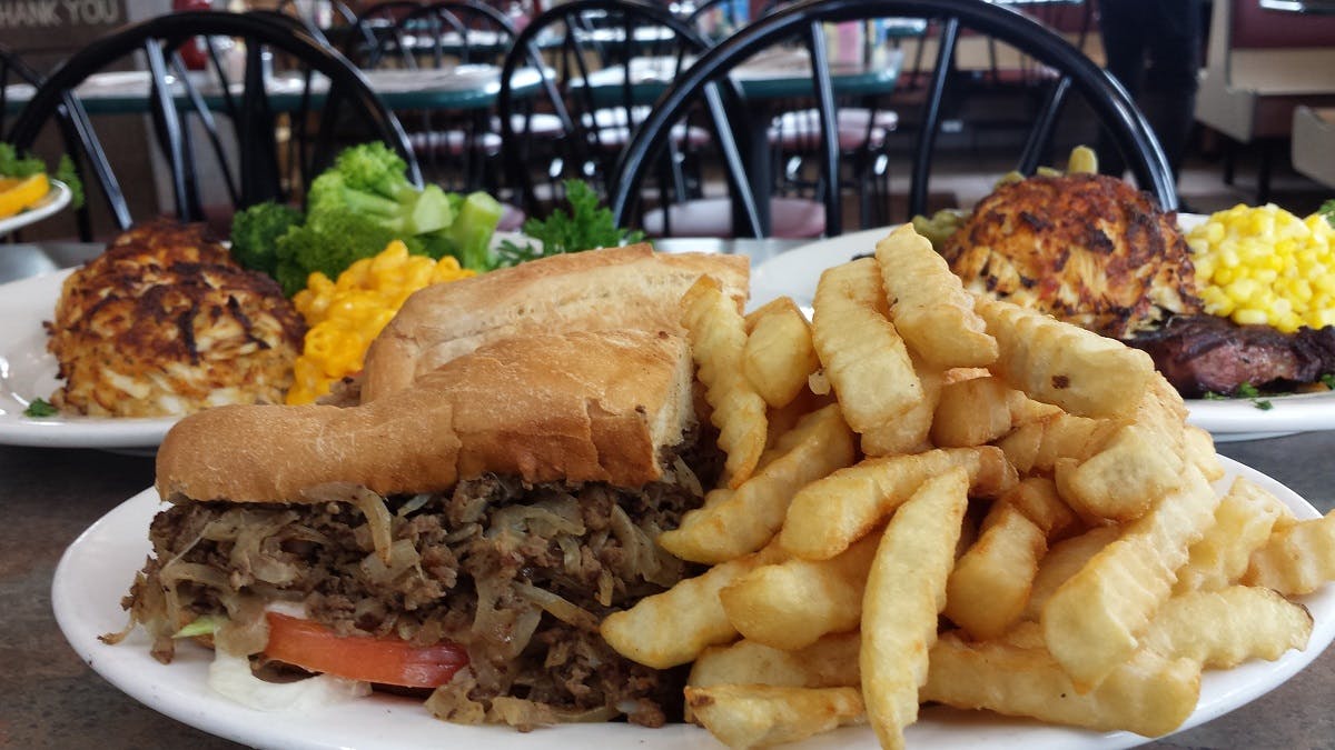 a plate of food with a sandwich and fries on a table