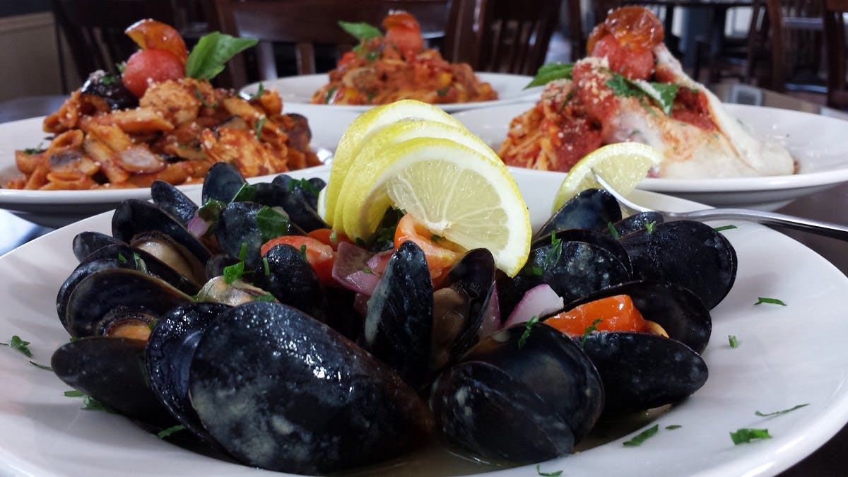 Black seafood dish with lemon slices.