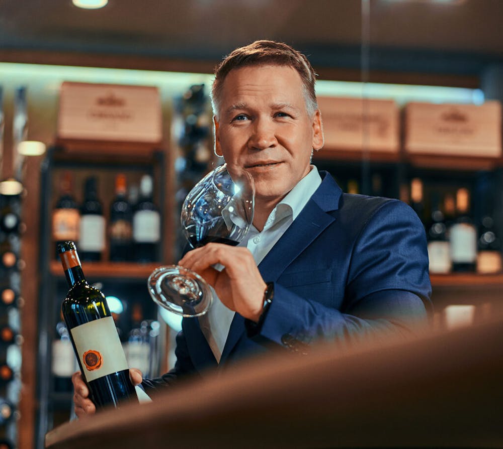 a man sitting at a table with wine glasses