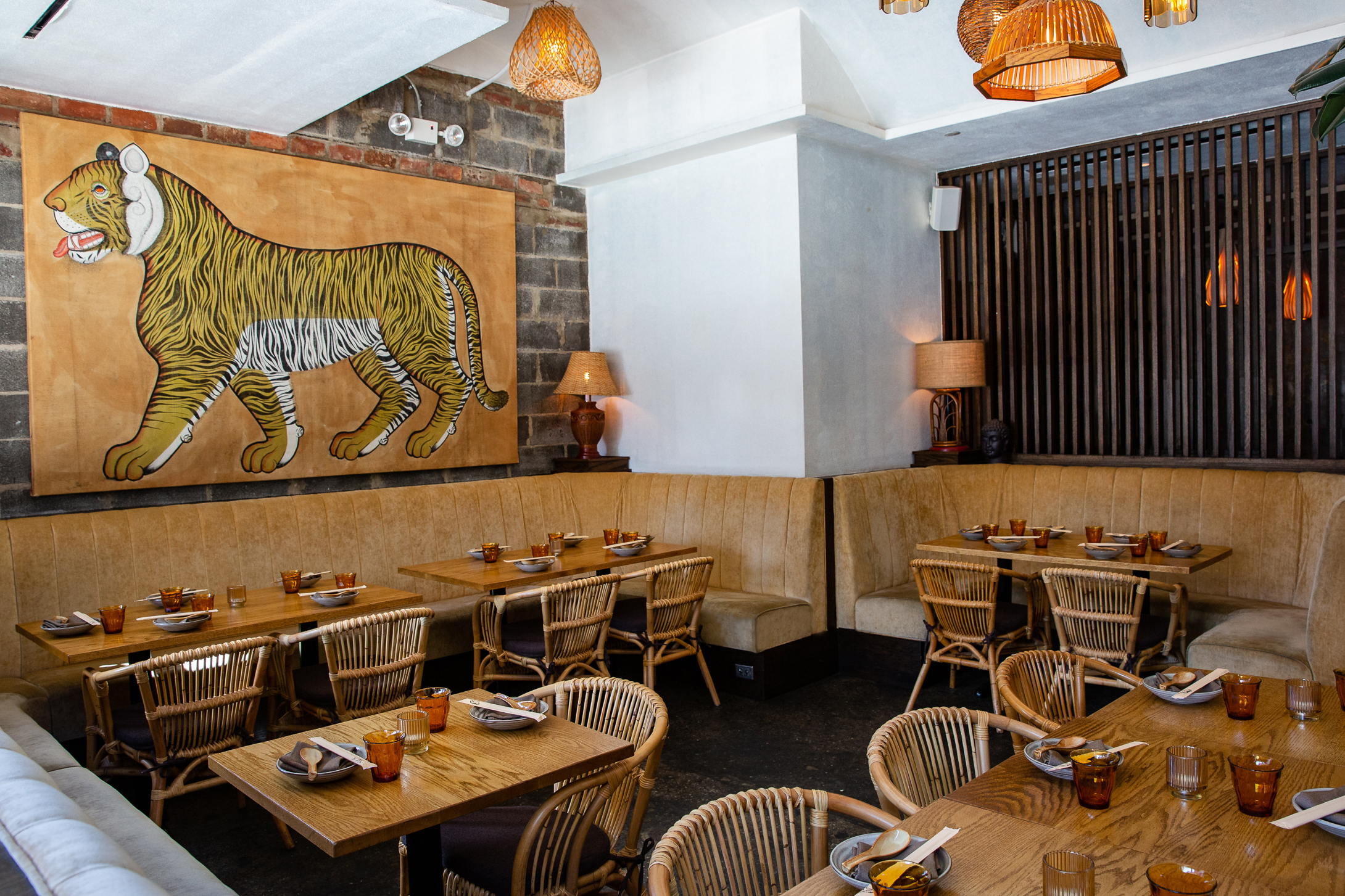 a beautifully set dining room with a large painting of a tiger on the wall.