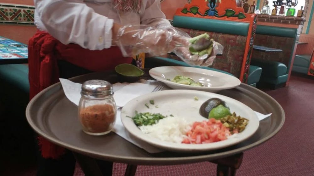 a woman sitting at a table with a plate of food