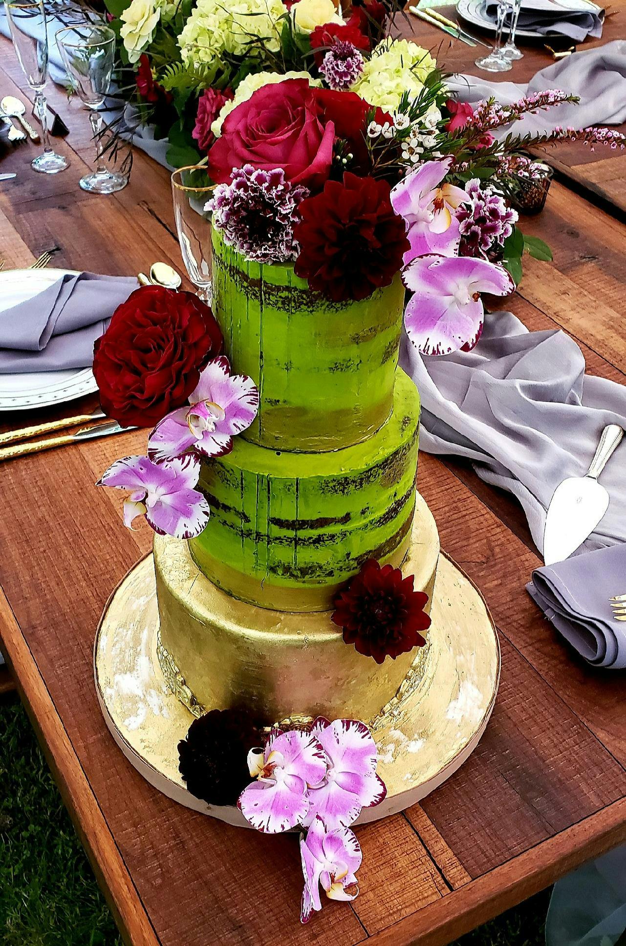 a cake sitting on top of a wooden table topped with a blue flower