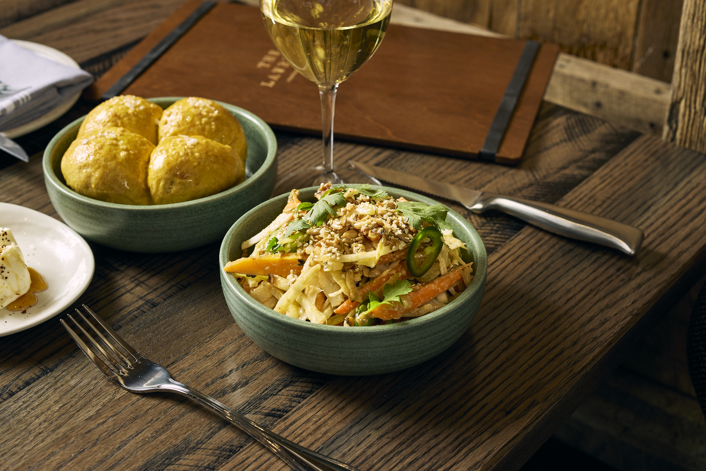 a bowl of food sitting on top of a wooden table