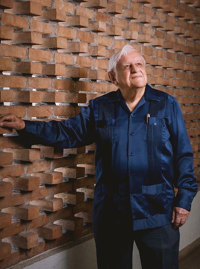 a man standing in front of a brick building
