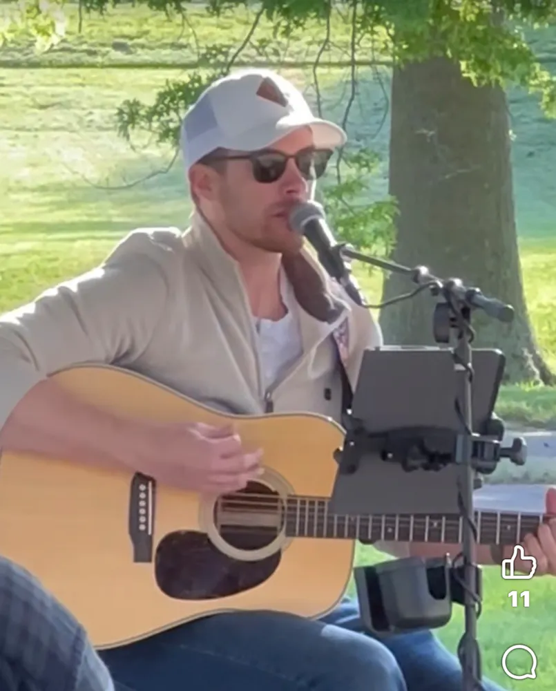 a man playing guitar and singing into a microphone