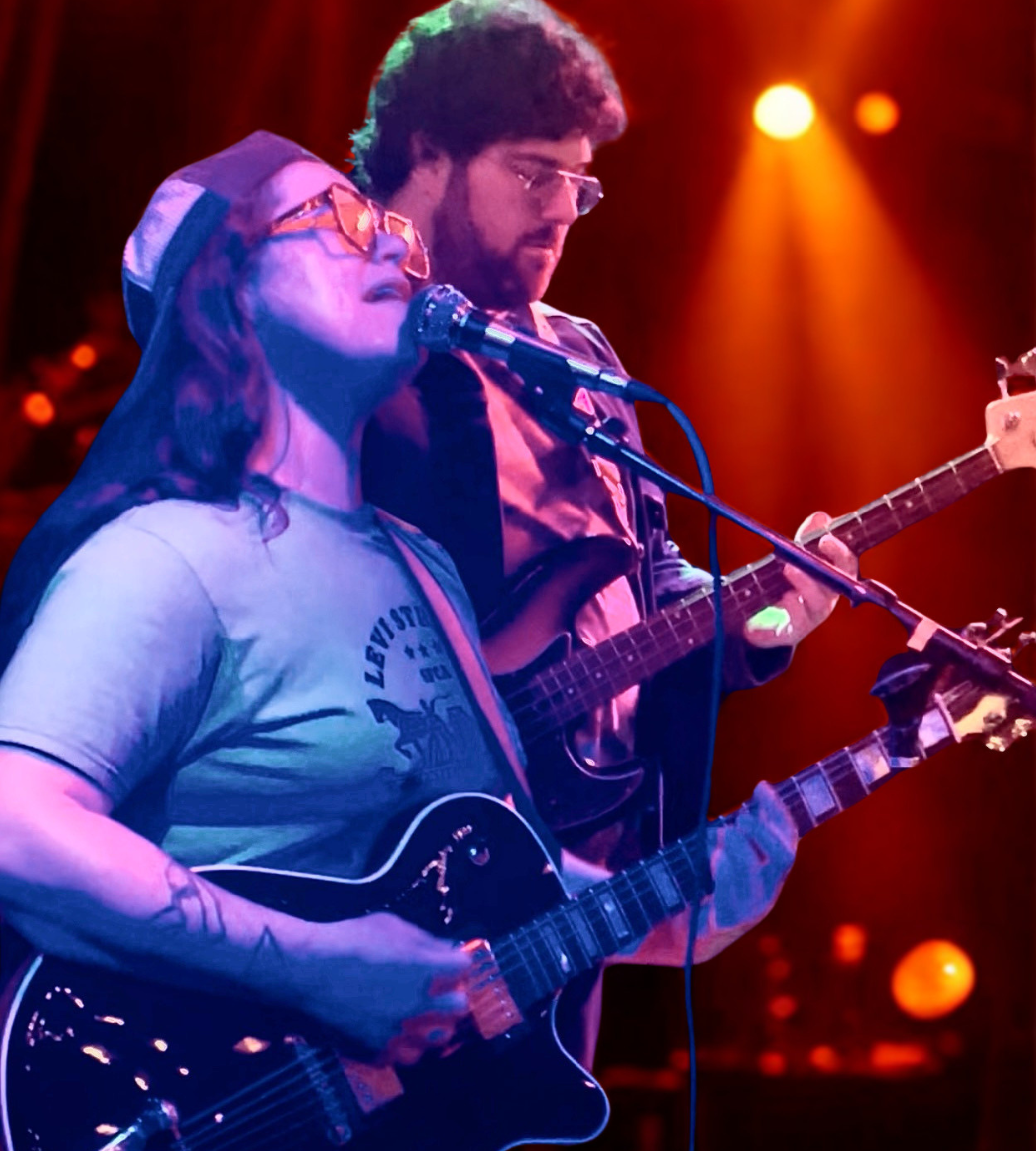 a man and woman playing guitars and singing