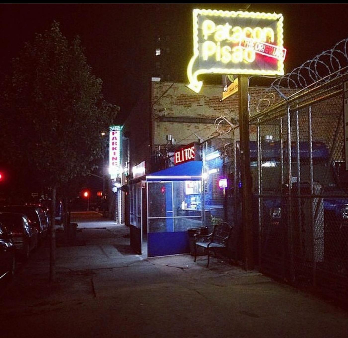 The truck under its neon Patacon Pisao sign on a dark Inwood street