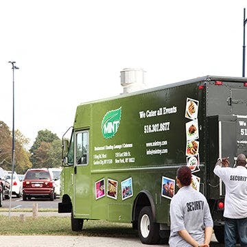 a group of people standing in front of a bus