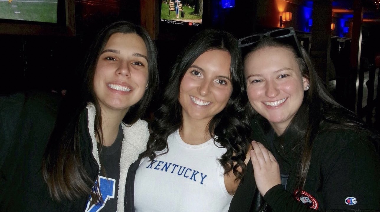 a group of girls cheering on Kentucky 
