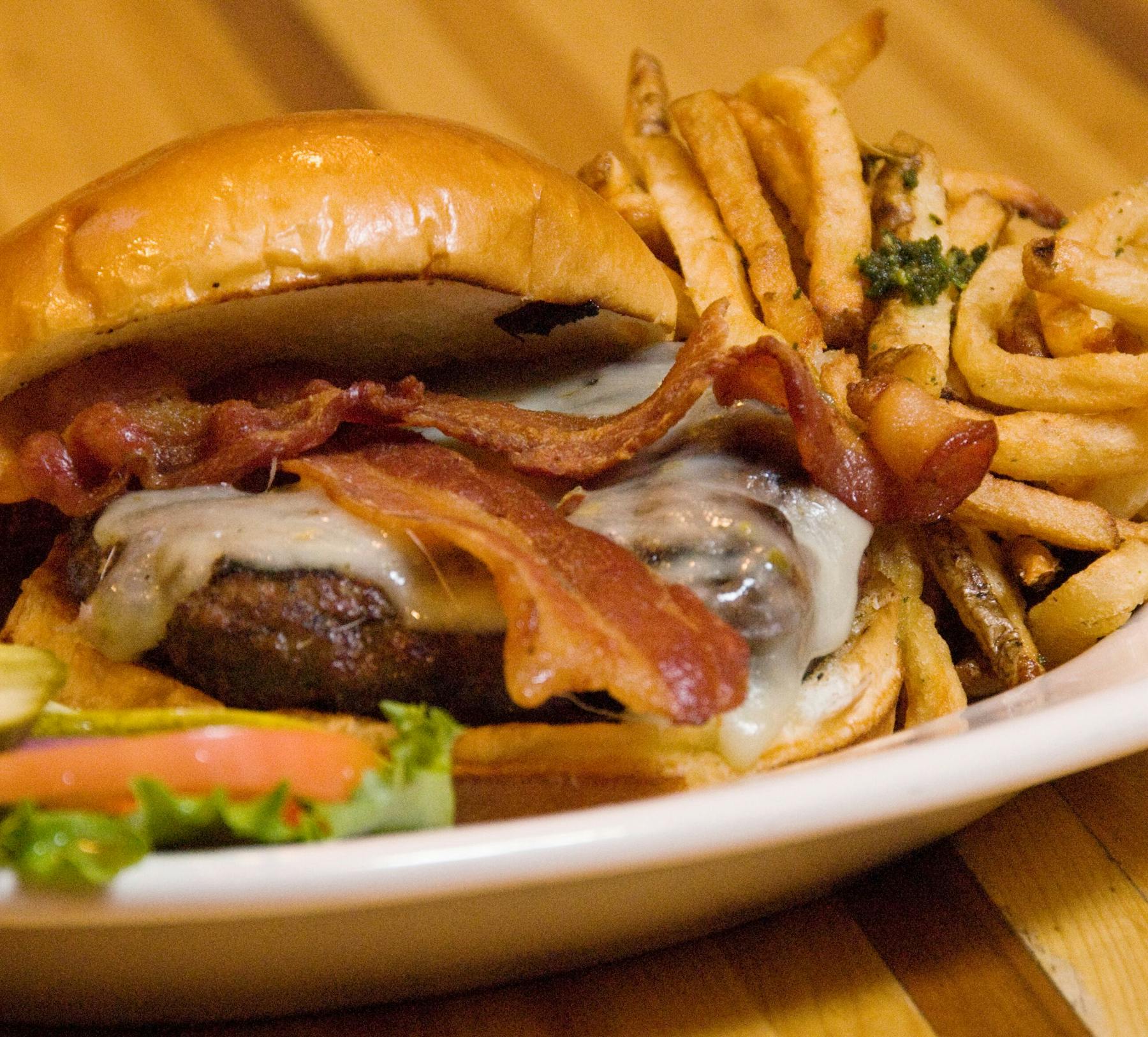 a close up of a hamburger and fries on a plate