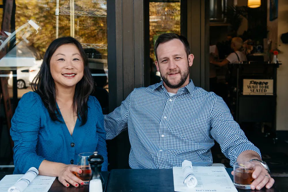 a couple of people sitting at a table posing for the camera