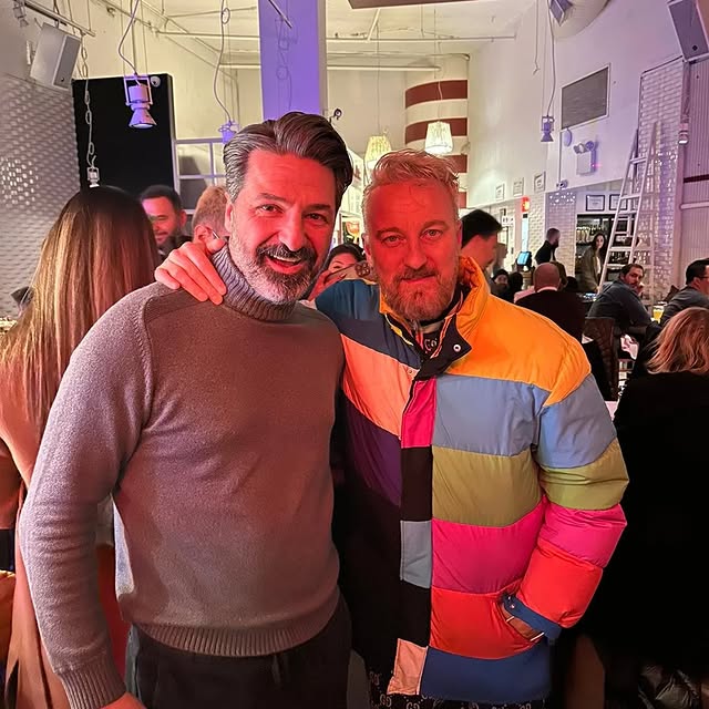 a man standing in front of a brick building