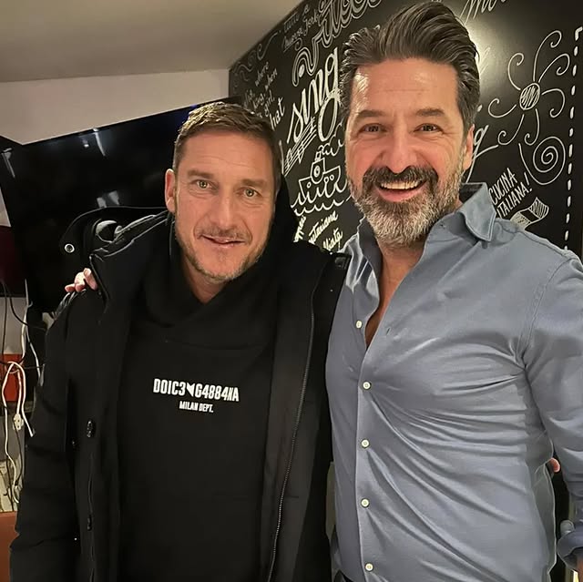 a man standing in front of a brick building