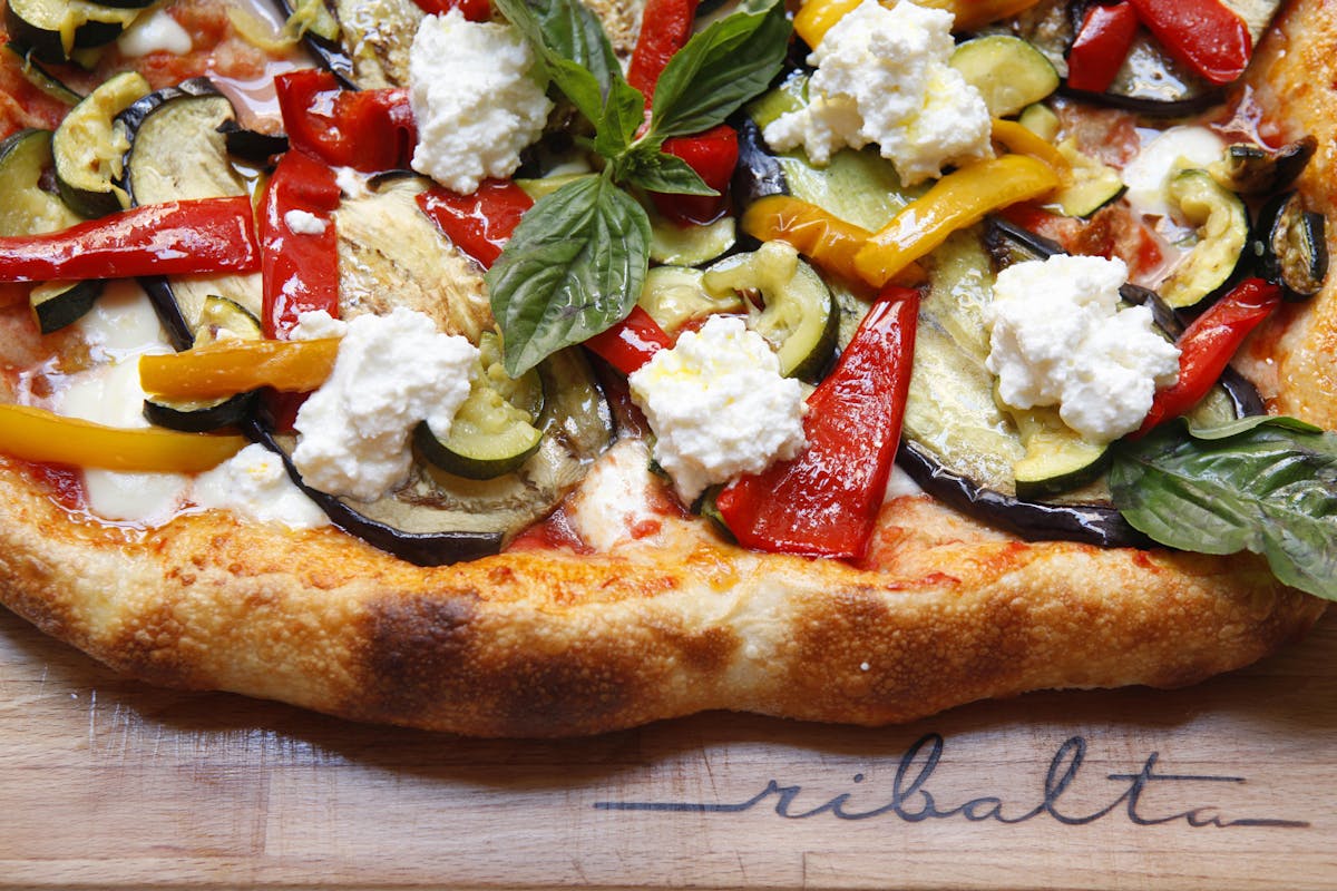 a pizza sitting on top of a wooden table