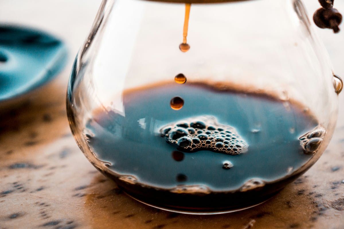 coffee pot, pouring coffee into a glass jar