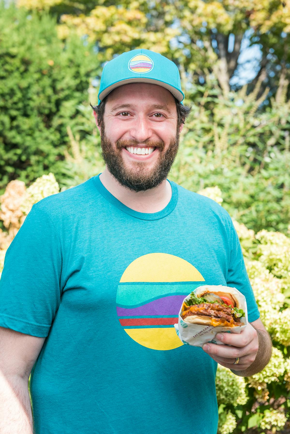 a man in a blue shirt holding a sandwich