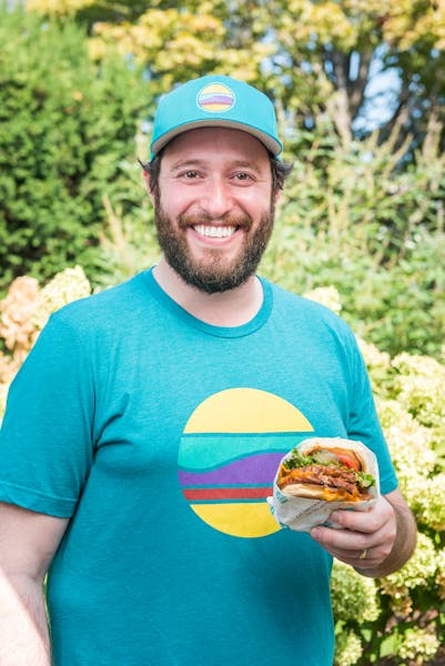 a man in a blue shirt holding a sandwich