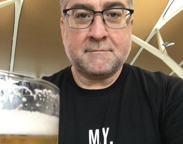 a man wearing glasses and smiling at the camera