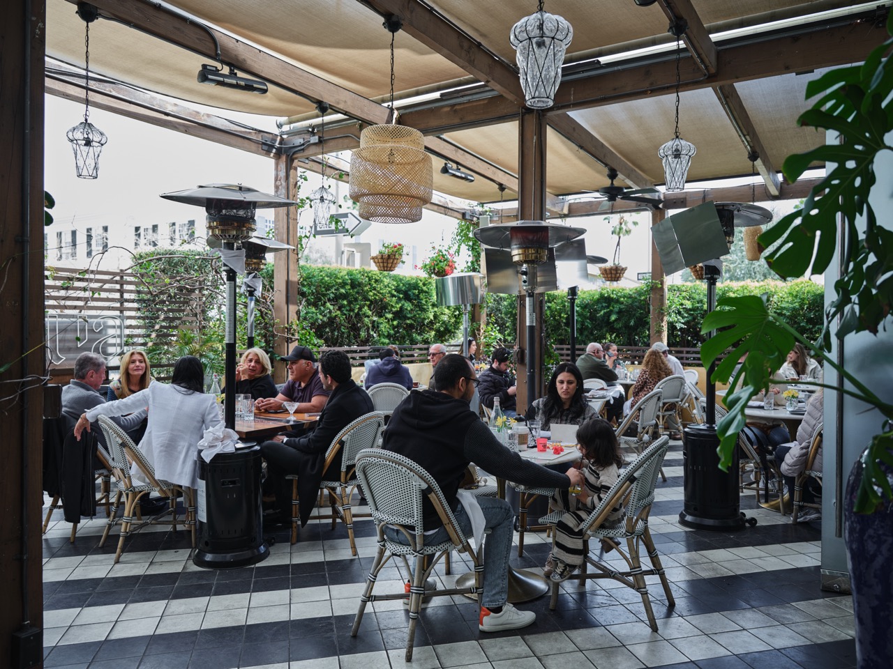 a group of people sitting at a table in front of a building