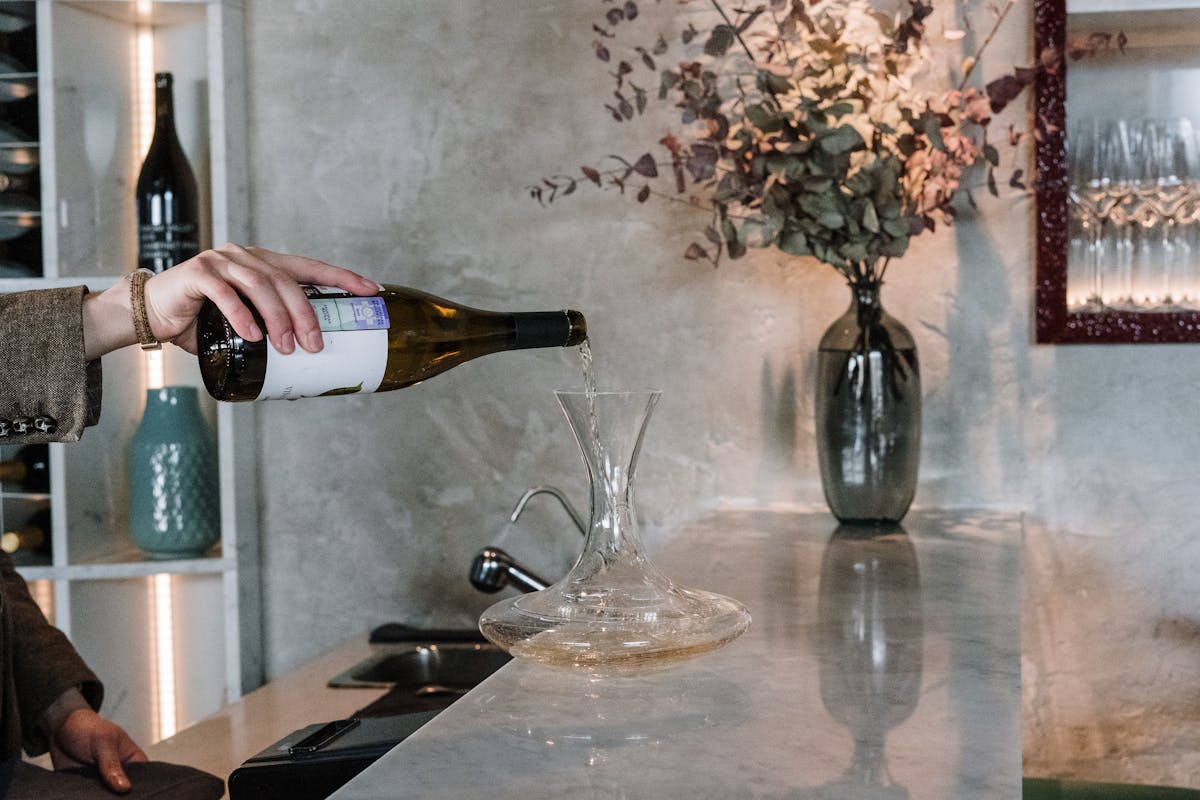 a person holding a bottle of wine on a table