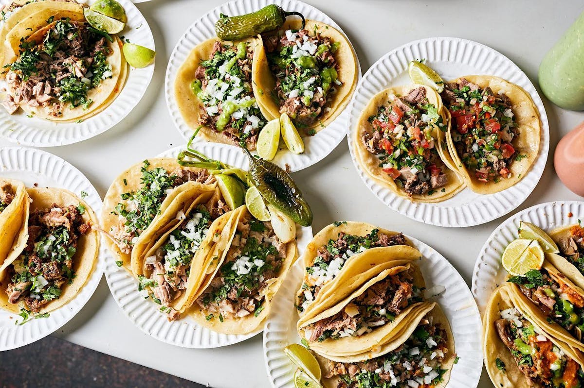 four plates of mini tacos on each