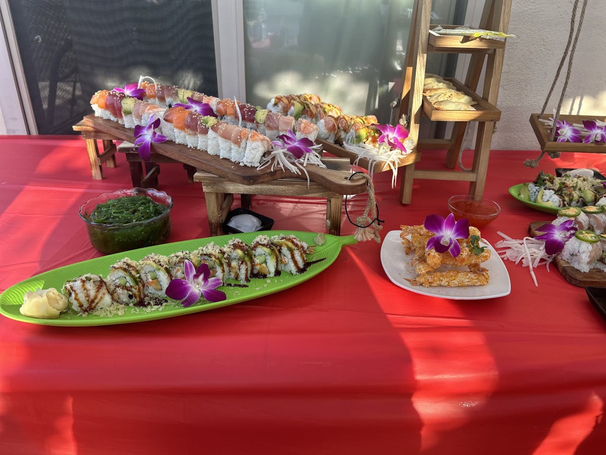 a pink plate topped with a vase of flowers on a table
