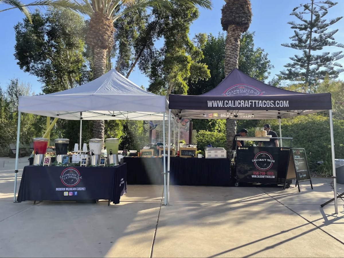 Cali Craft tacos booth setup with drinks on one table and food on the other