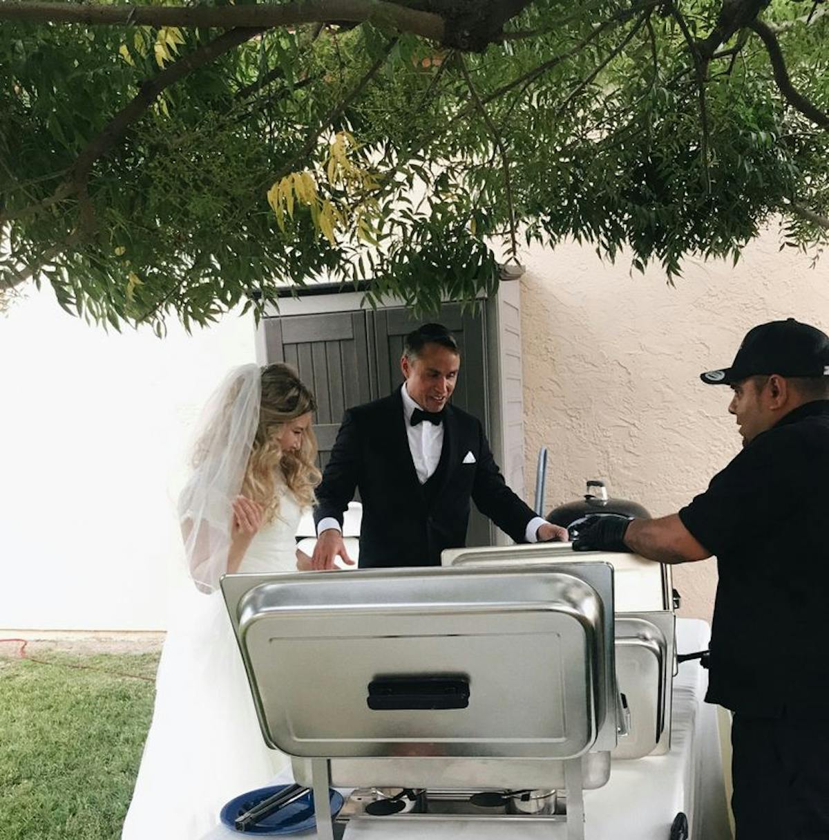 A newlywed couple being first to grab food in a catered buffet from Cali Craft Tacos