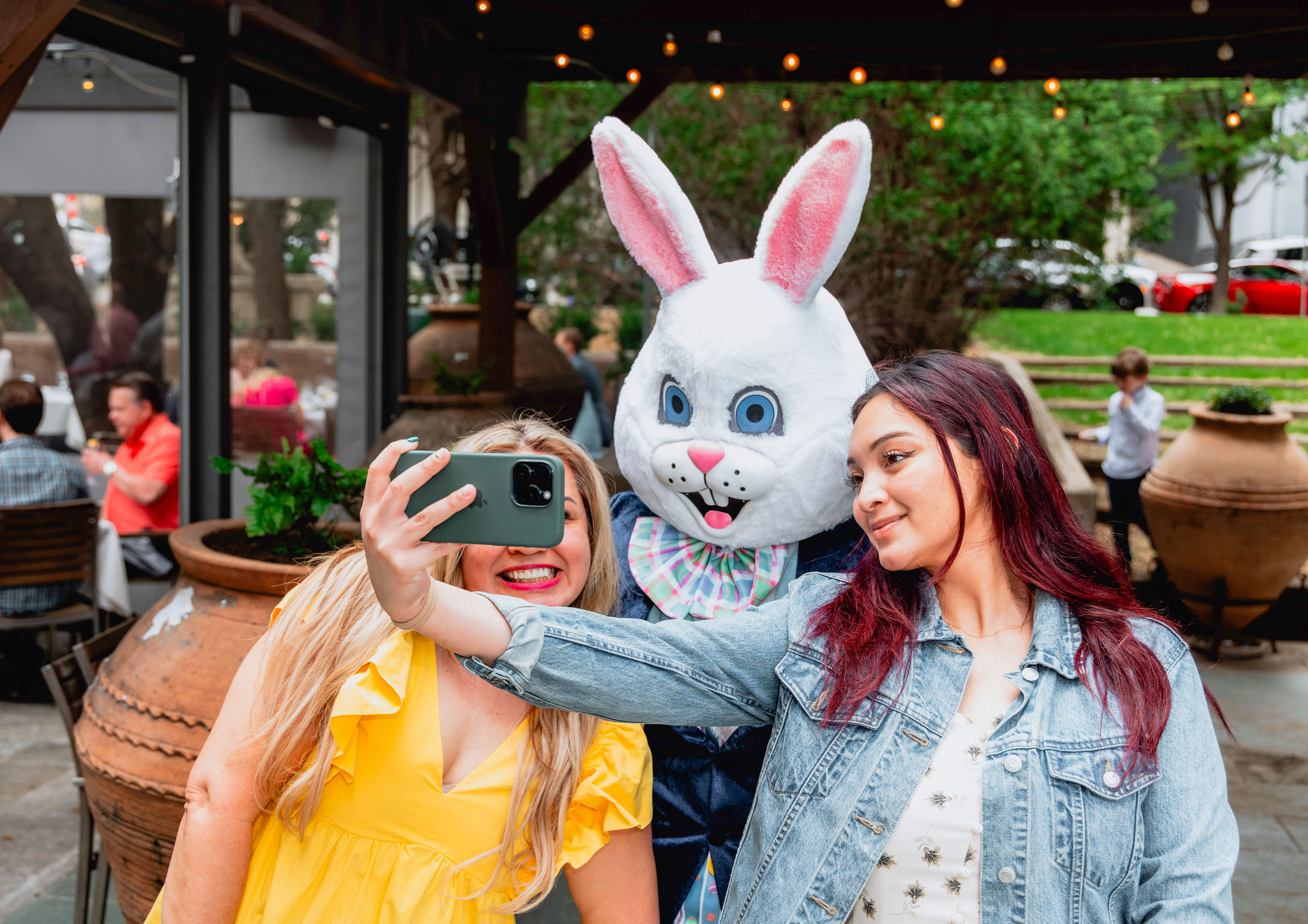 a group of women taking a selfie with a person in a bunny garment
