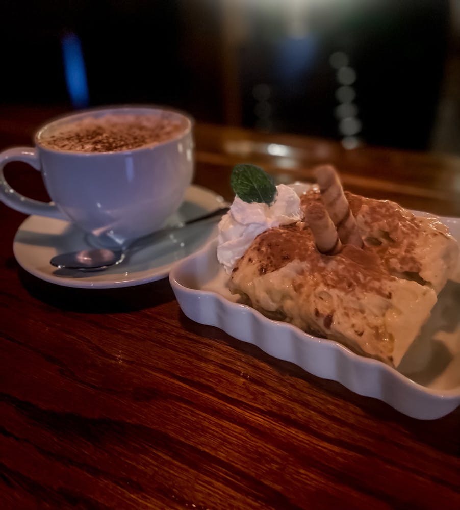 a piece of cake on a plate next to a cup of coffee