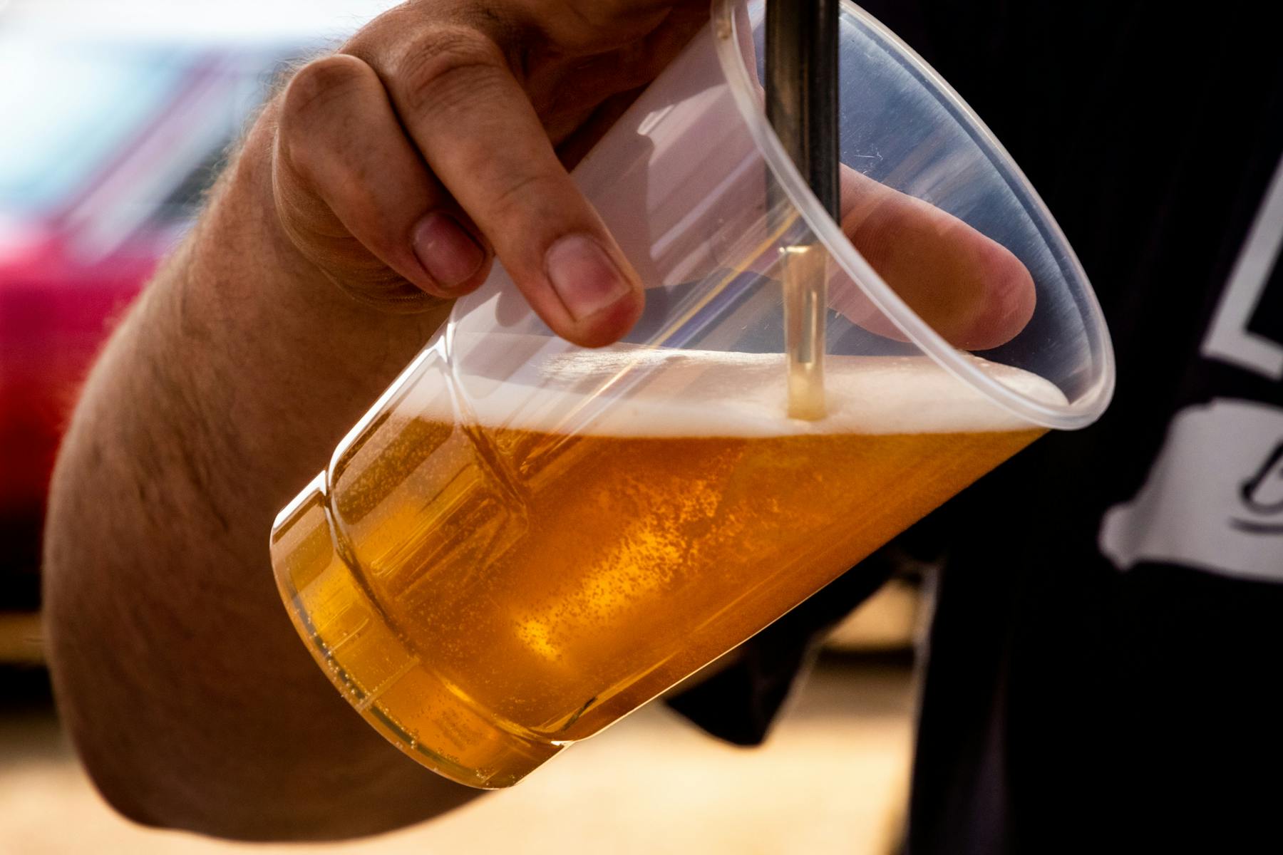 a hand holding a glass of beer on a table