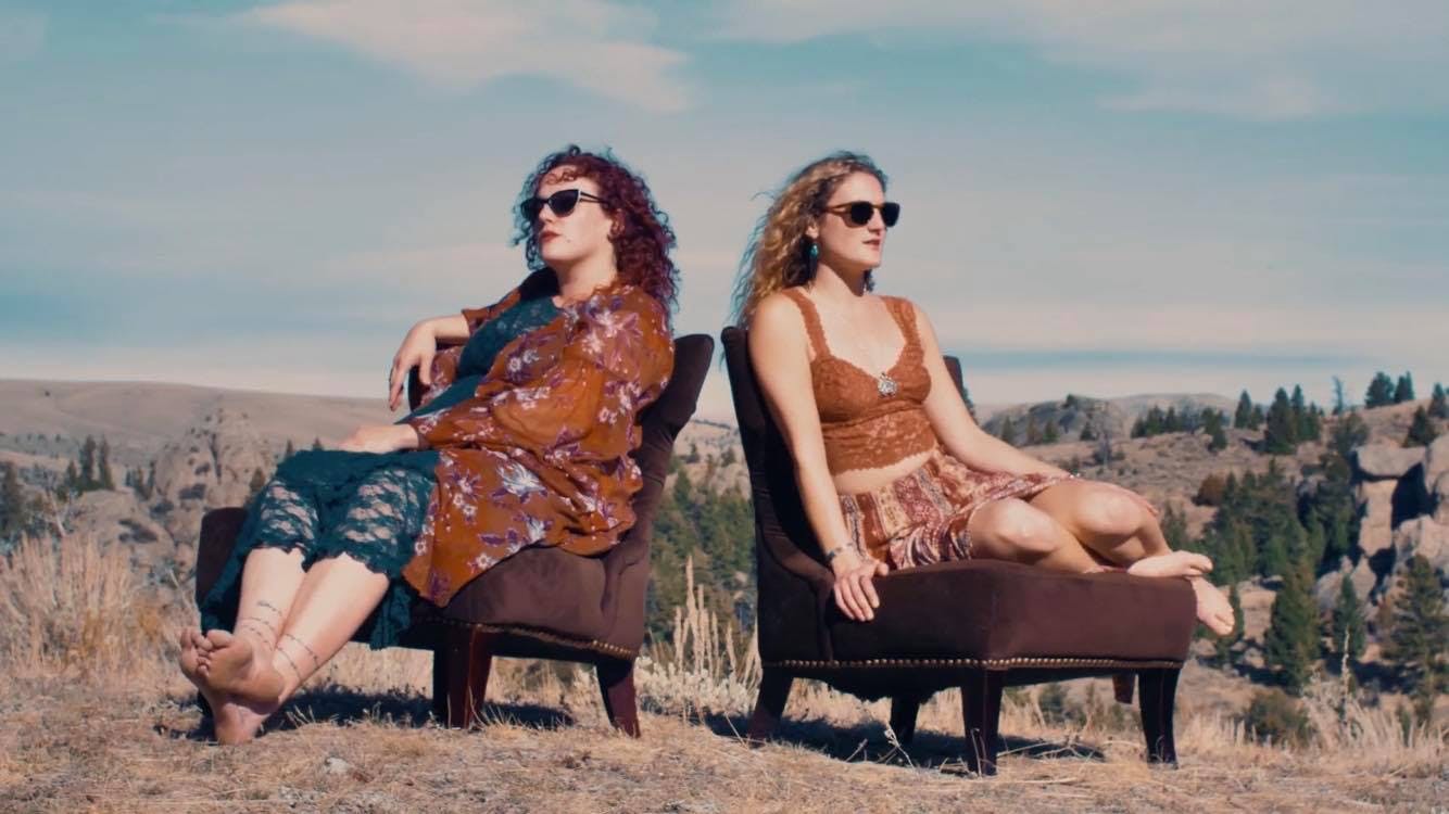 a group of people sitting in the grass