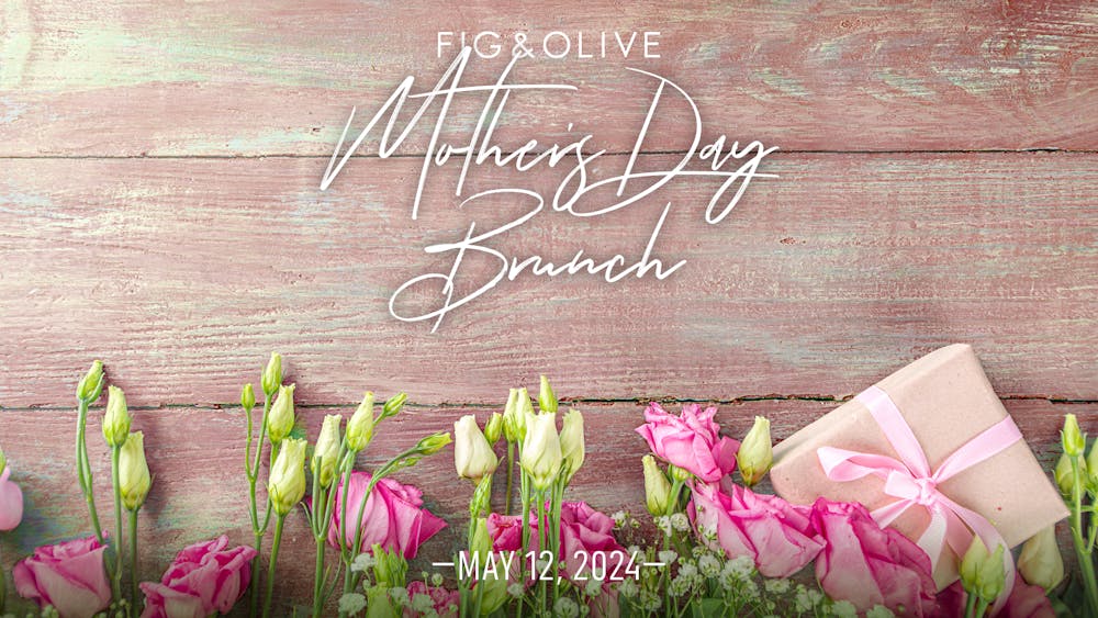 FIG & OLIVE | Mother's Day Brunch | Image of flowers on wooden planks with a wrapped package.