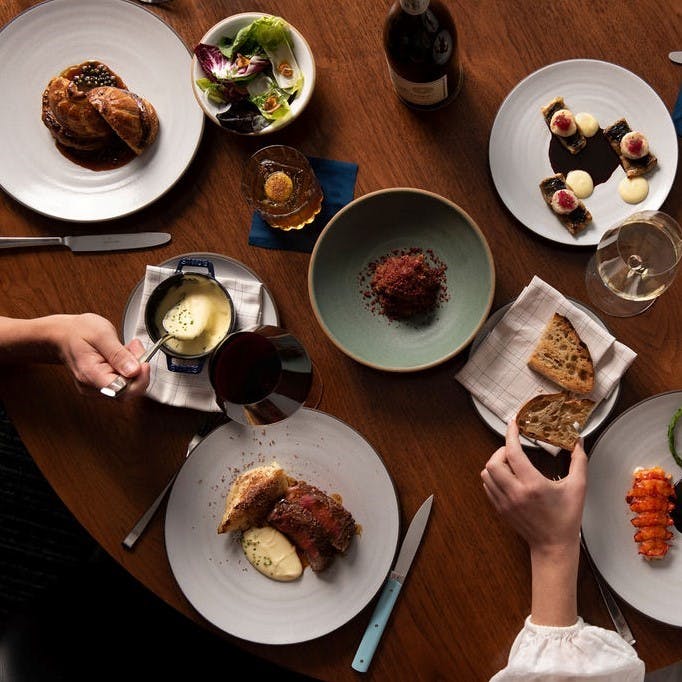 a group of people sitting at a table with a plate of food