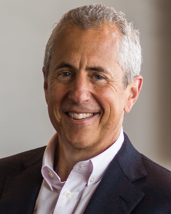 Danny Meyer wearing a suit and tie smiling at the camera