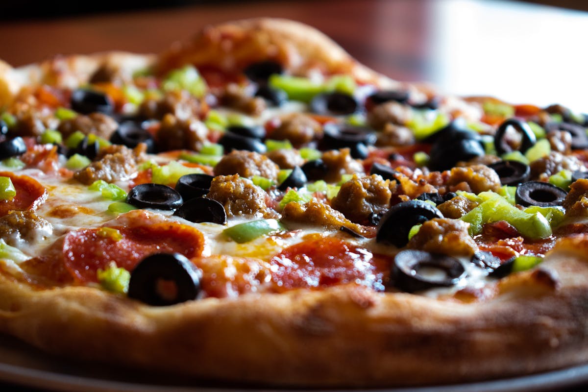 a pizza sitting on top of a wooden cutting board