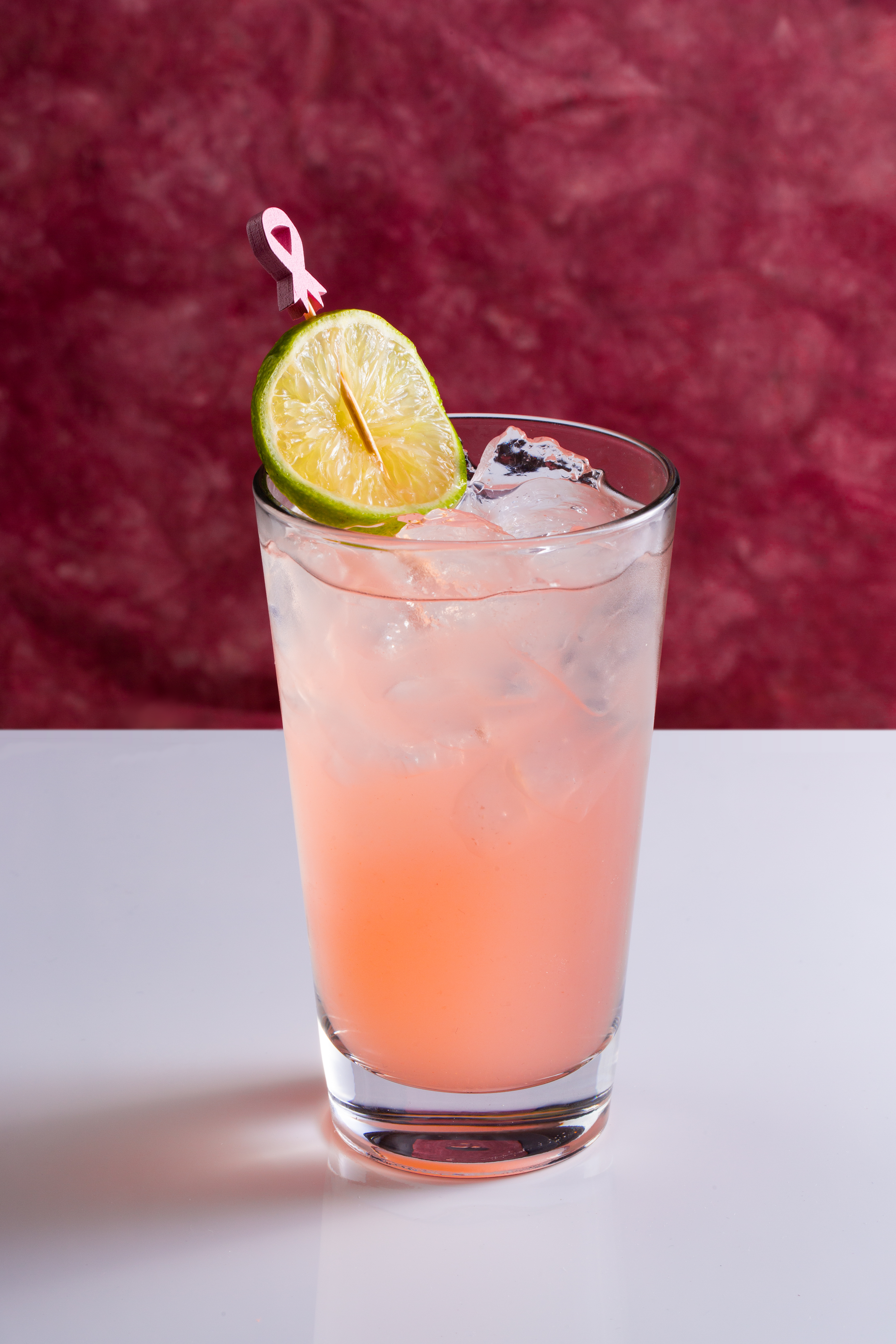 a glass with a drink and a lime on it