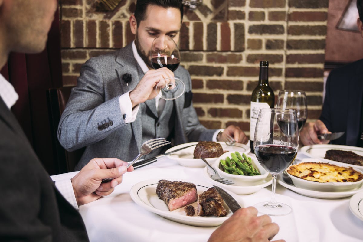a man and a woman sitting at a table with a plate of food