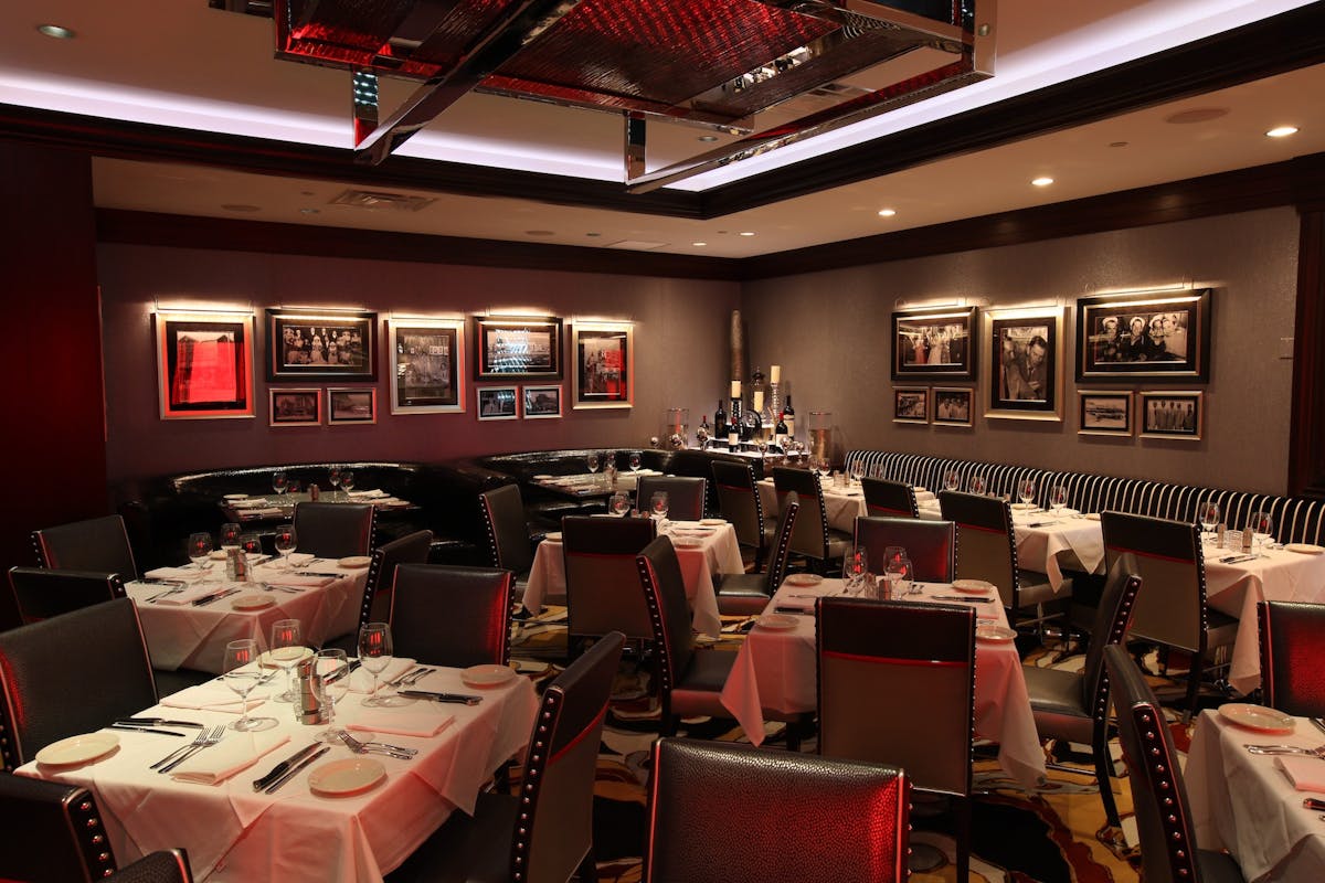 a room with many square tables in a restaurant